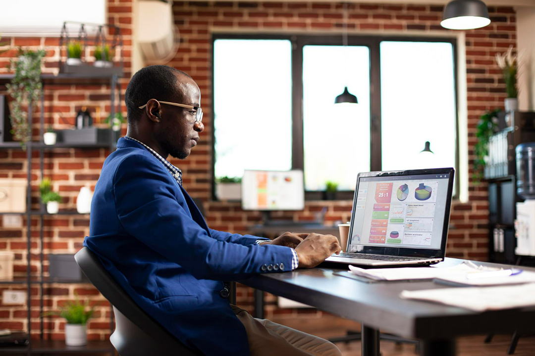 A man sitting at his office desk working on his computer.